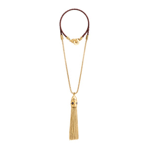 Collar de cadena dorada con borla decorativa colgante y cierre de cuero trenzado marrón.