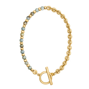 Brazalete con cuentas en tonos azul claro y dorado, complementado con una cadena dorada y cierre estilo Omega.