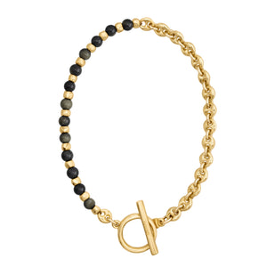 Brazalete con cuentas en tonos negros y dorado, complementado con una cadena dorada y cierre estilo Omega.