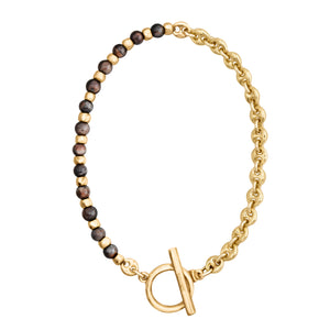 Brazalete con cuentas en tonos marrones oscuros y dorado, complementado con una cadena dorada y cierre estilo Omega.