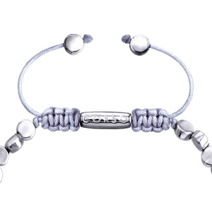 Primer plano de cierre ajustable de una pulsera de cuentas plateadas con un cordón entrelazado.