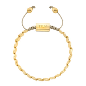 Pulsera dorada con cuentas ovaladas y cordón ajustable beige, con detalle metálico central que dice "CORSO".