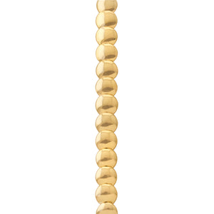 Primer plano de una cadena de cuentas doradas redondas, alineadas verticalmente.