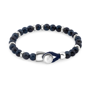 Pulsera de cuentas azul oscuro con separadores de metal plateado y un cierre de hebilla plateado, asegurado con un lazo de cordón azul.